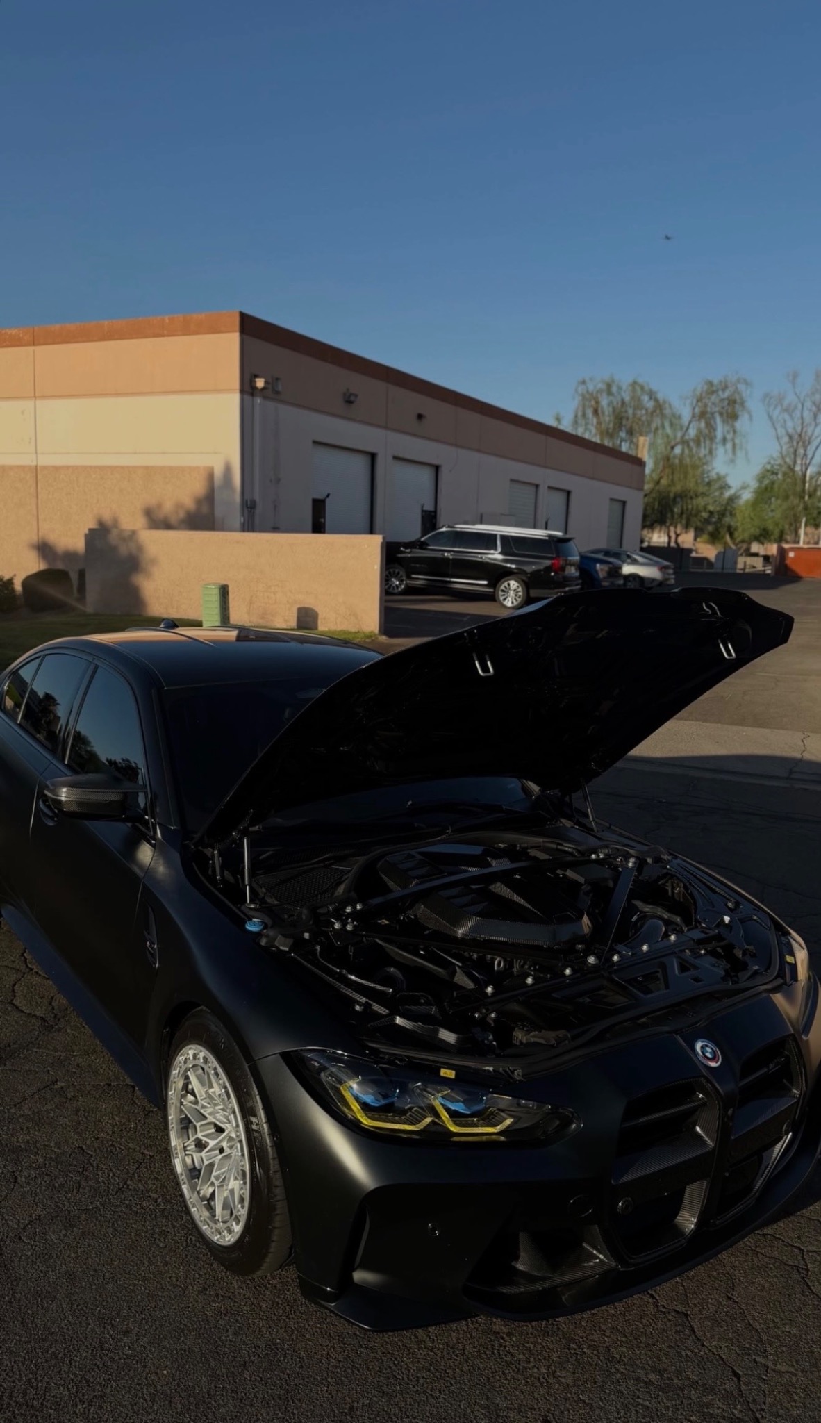 Black performance car with hood open