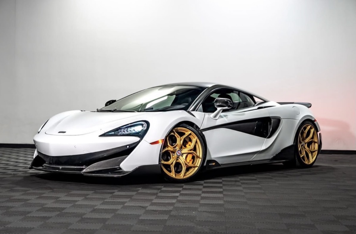 White exotic sports car with gold wheels